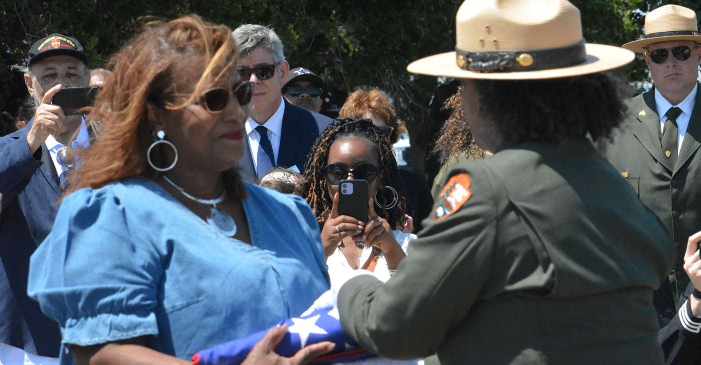 Carol Cherry, left, was presented with the Stars and Stripes flag by Kelli English, right, from the National Park Service to conclude the ceremony. Her father, Cyril Oscar Sheppard, Jr., was one of the 50 Black sailors convicted of mutiny after the explosions at Port Chicago killed 320 people in 1944. CBM photo by Antonio R. Harvey