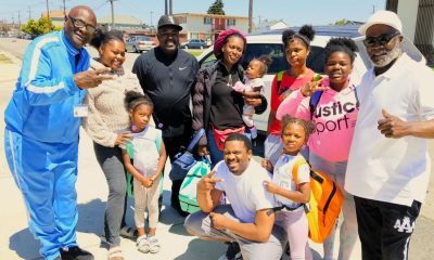 Rev. Andre Shumake, far right, and Antwon Cloird, far left, pose with recipients of the back-to-school supplies. Photo by Mike Kinney.