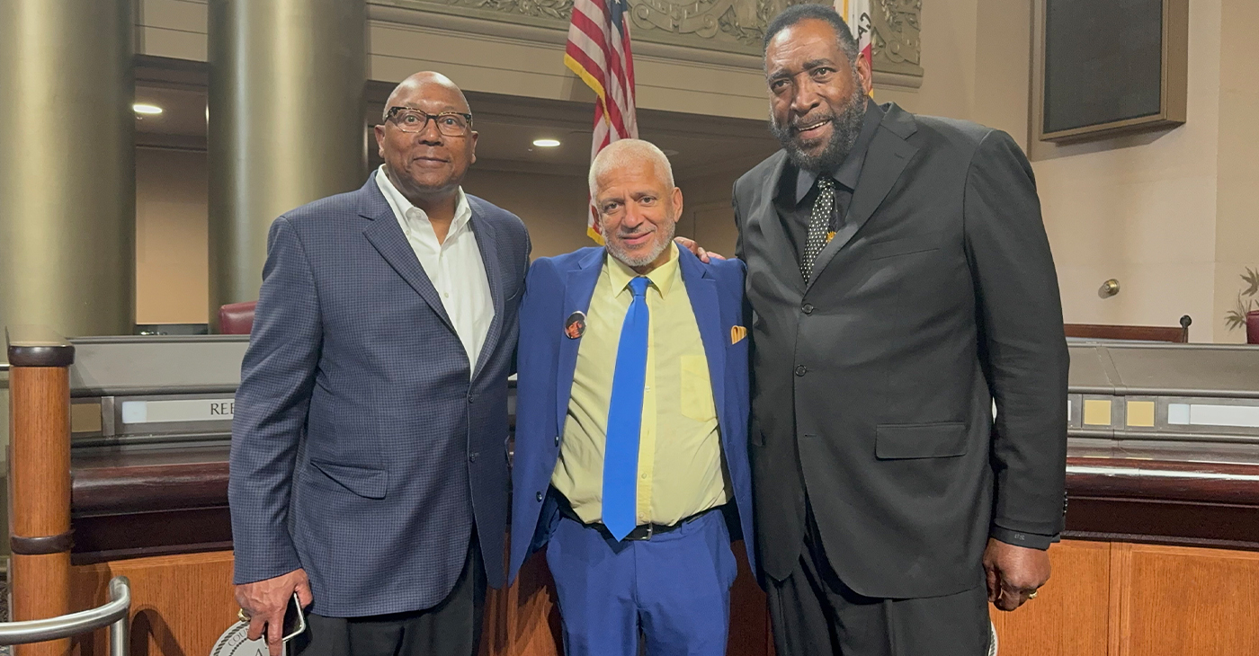 Members of the 1975 NBA championship team, Charles Dudley (left) and Clifford Ray (right) embrace Love Life Foundation leader Donald Lacy for his antiviolence mission. Courtesy photo.