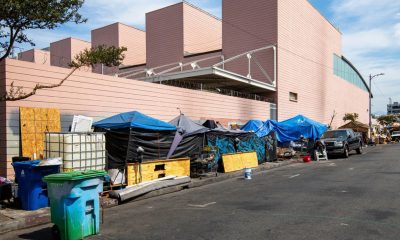 Shutterstock. Los Angeles, CA. USA: 2024 August 01: Homeless, unhoused people living in an encampment, temporary shelters and tents on the sidewalk.