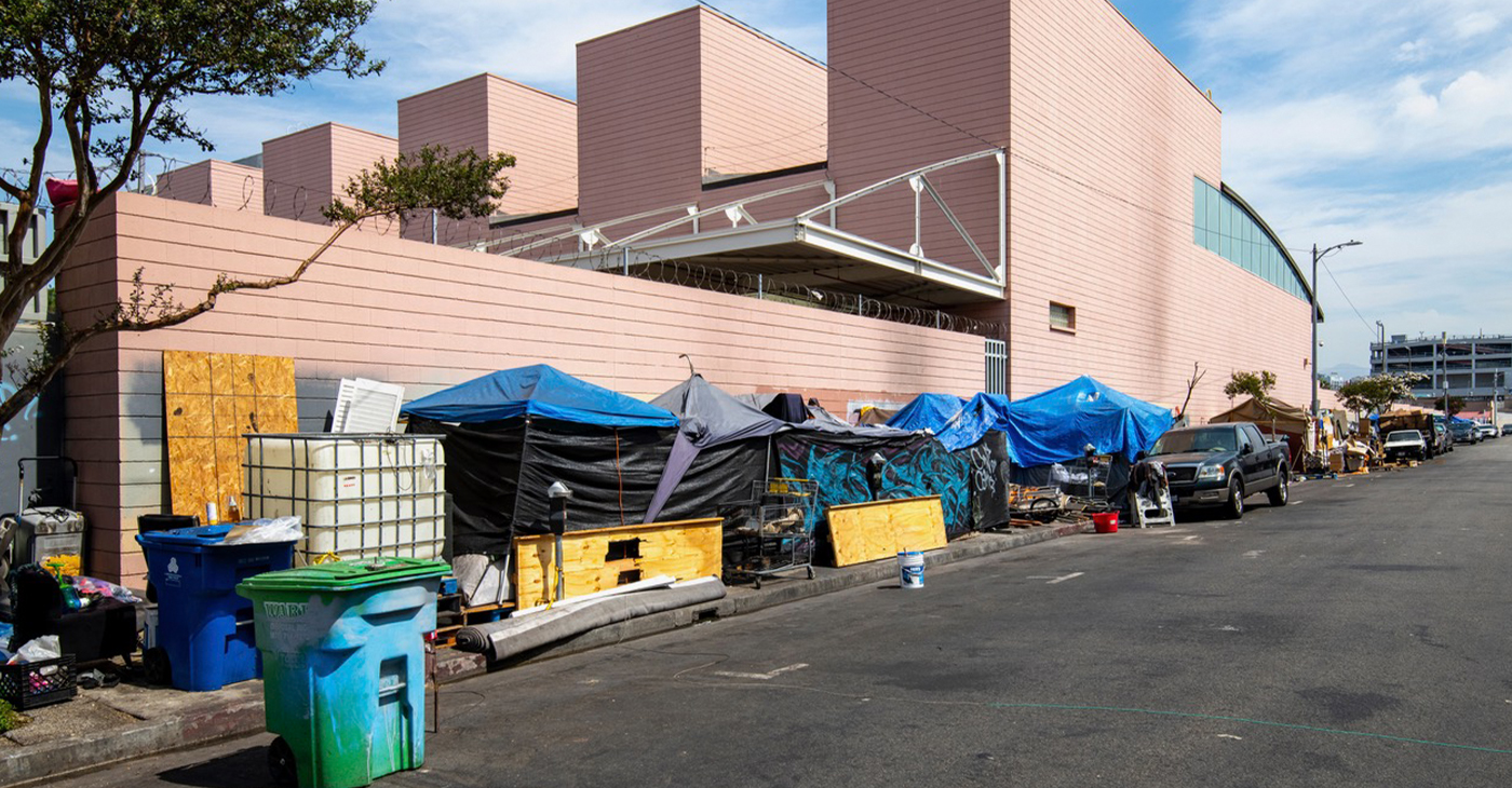 Shutterstock. Los Angeles, CA. USA: 2024 August 01: Homeless, unhoused people living in an encampment, temporary shelters and tents on the sidewalk.