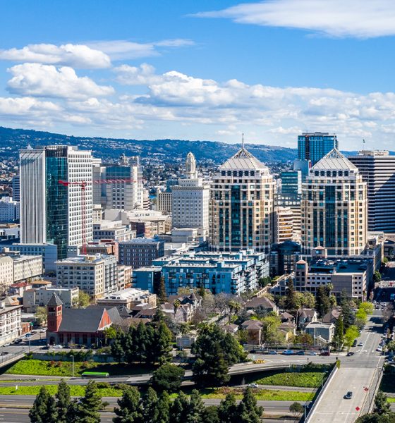 An aerial view of the downtown Oakland skyline on a clear sunny day. The federal building and other iconic buildings fill the skyline. Photo: iStock.