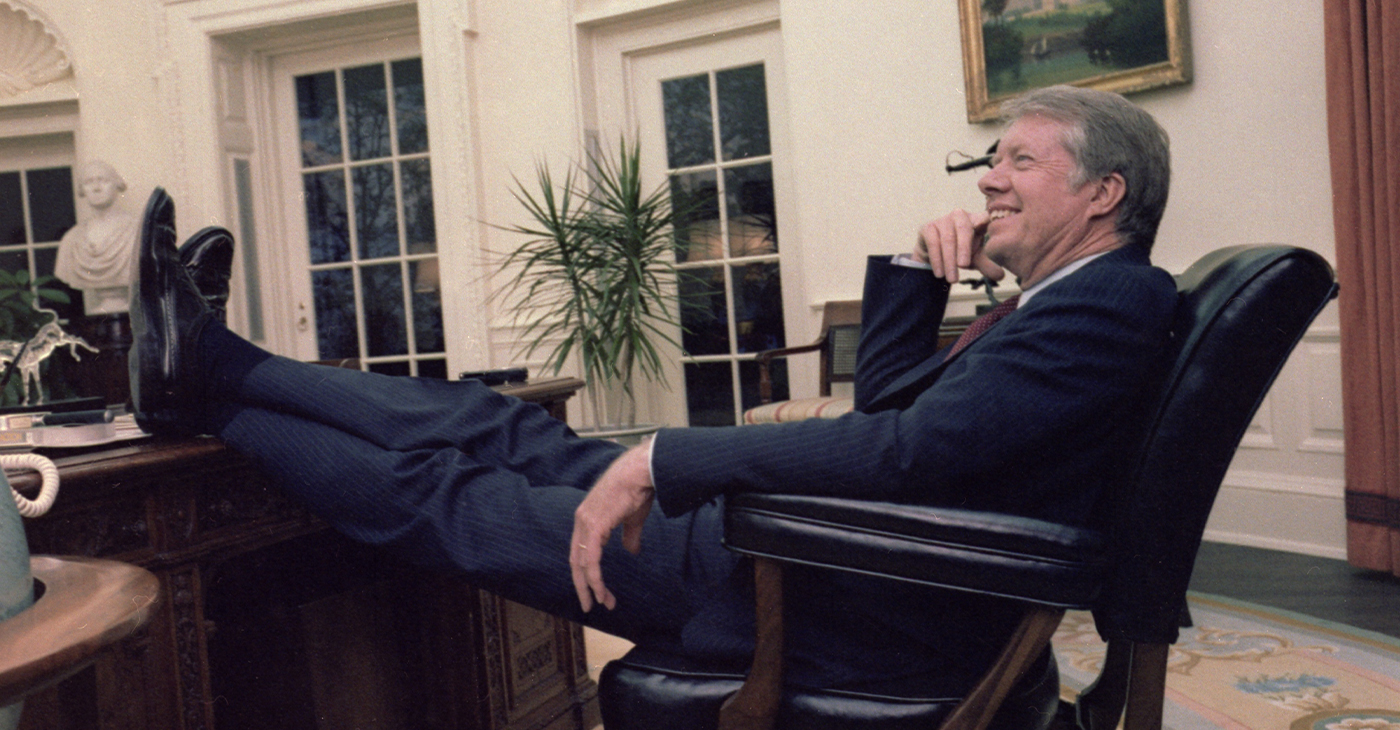 President Jimmy Carter sits casually with his feet on the table at the Resolute desk in the Oval Office of the White House on April 18, 1978. Photo by Valkoisen Tuntematon/Wikimedia Commons.