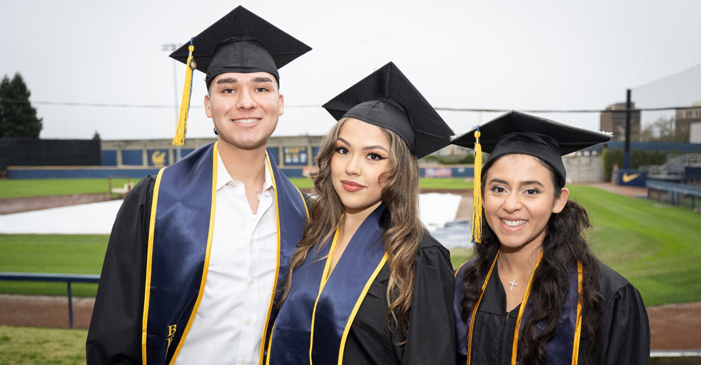 Lester Cedeño, left, and Jamie Hernandez, both of San Bernardino, California, pose with Monica Gomez of Vallejo, right, after the graduation ceremony. Photo by Keegan Houser/UC Berkeley.