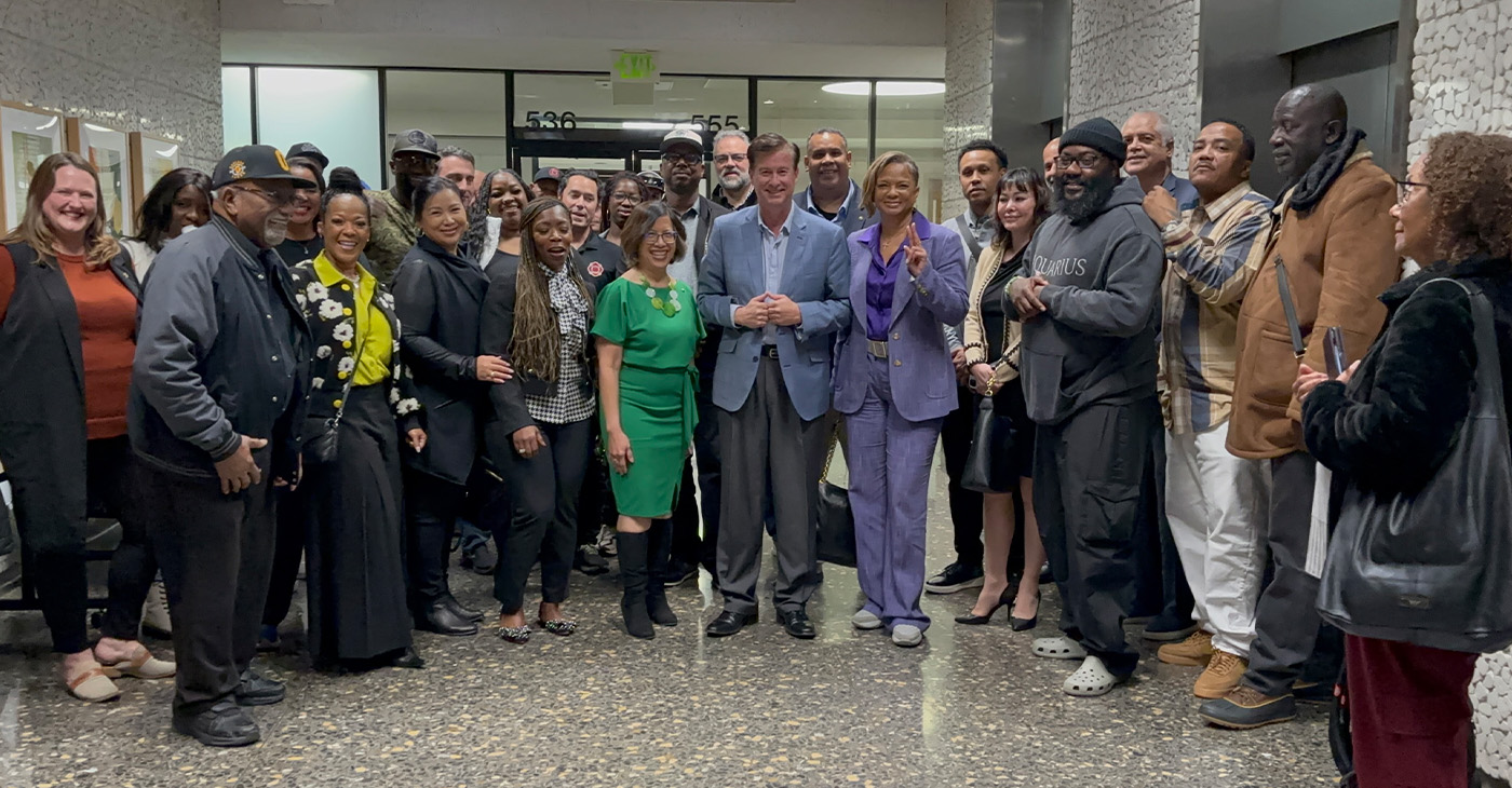 Oakland Coliseum project supporters celebrate Alameda County Board of Supervisors decision to endorse the project on Jan. 14. Supervisor Nikki Fortunato Bas (in green dress) is at the center of the crowd. Photo courtesy of Bas’s office.