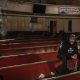 Pastor Rodney sits in the church's sanctuary following the devastating three alarm fire in 2023.